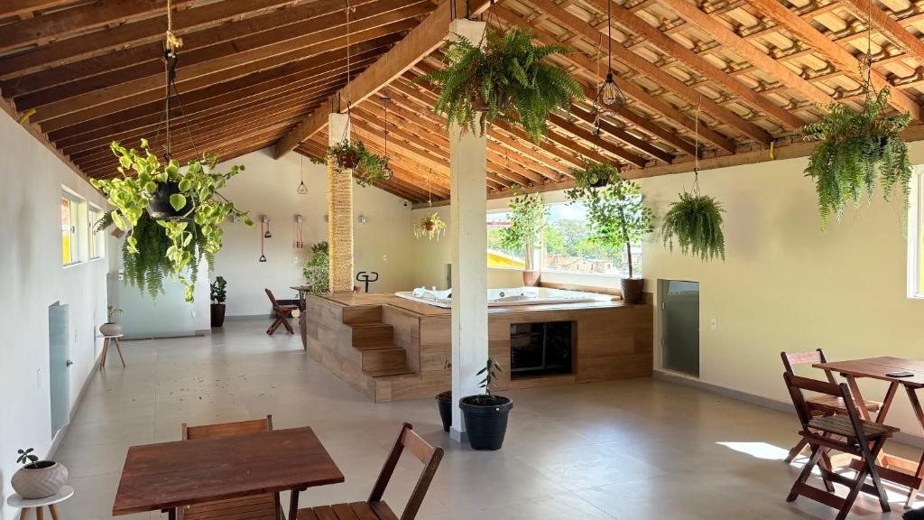 Terraço coberto com plantas suspensas, mesas de madeira e a hidromassagem